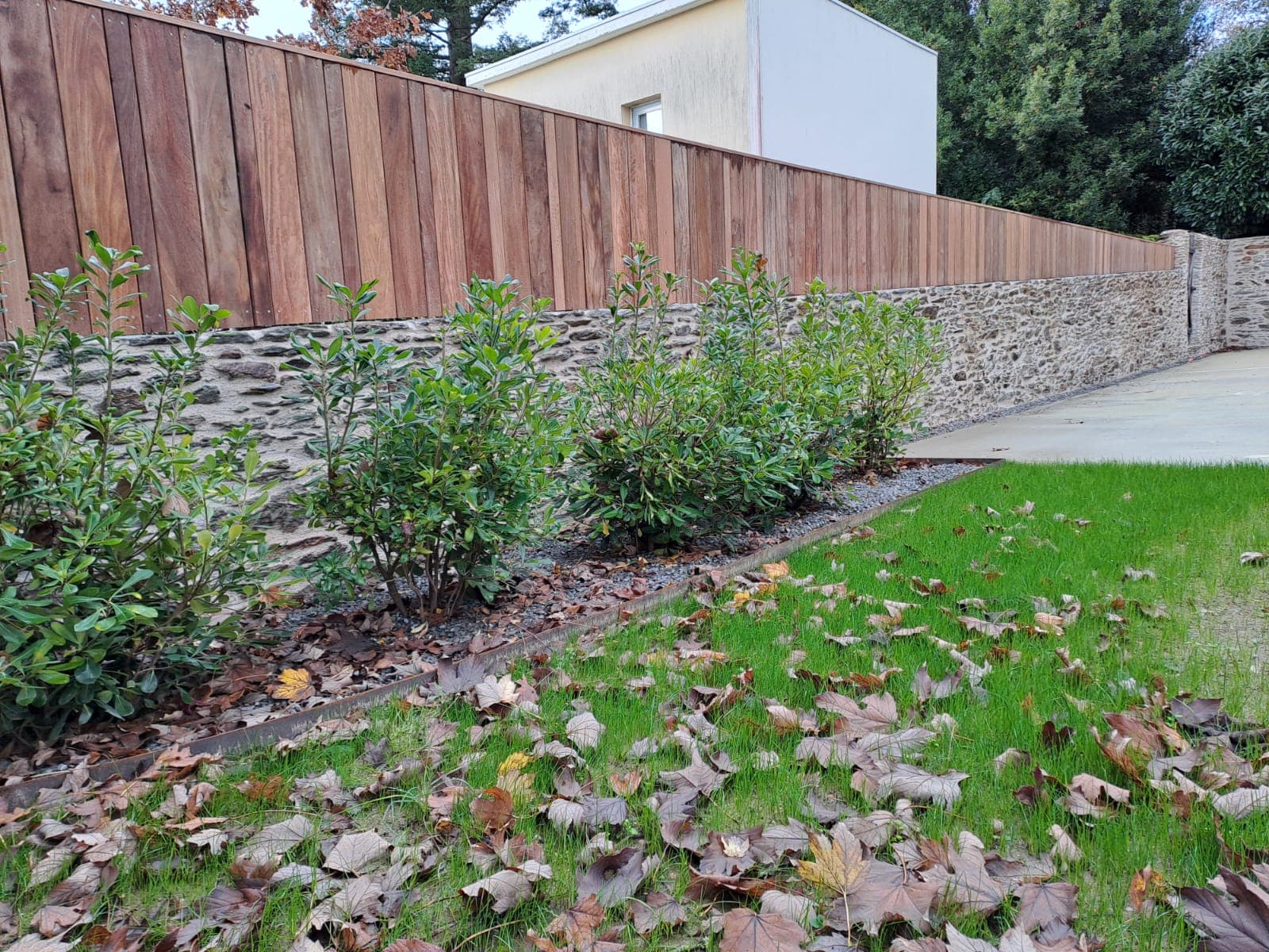 Aménagement extérieur durable réalisé par Erdre Paysage à Sucé-sur-Erdre, associant végétal, engazonnement et clôture bois.